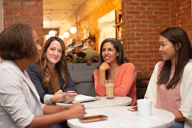 Women sitting around a coffee table talking Spanish