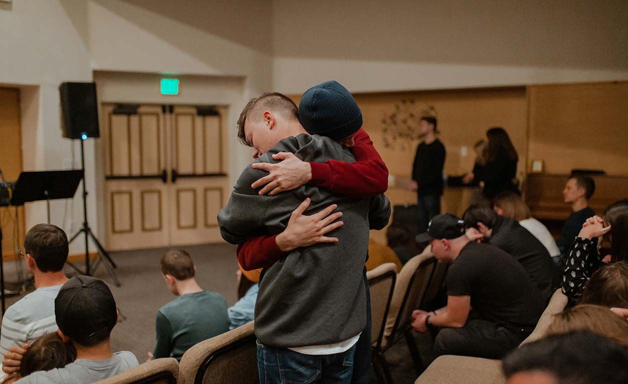 Young men hugging each other in church