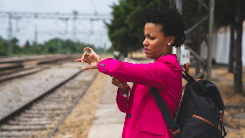 woman checking her watch to tell the time - What Time Is It In Portuguese - Lingopie