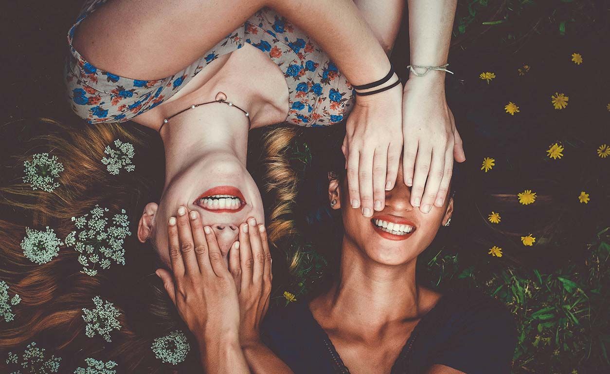 Girls liying on the grass with flowers