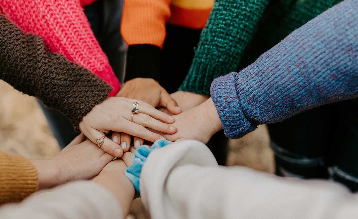 Friends putting their hands together